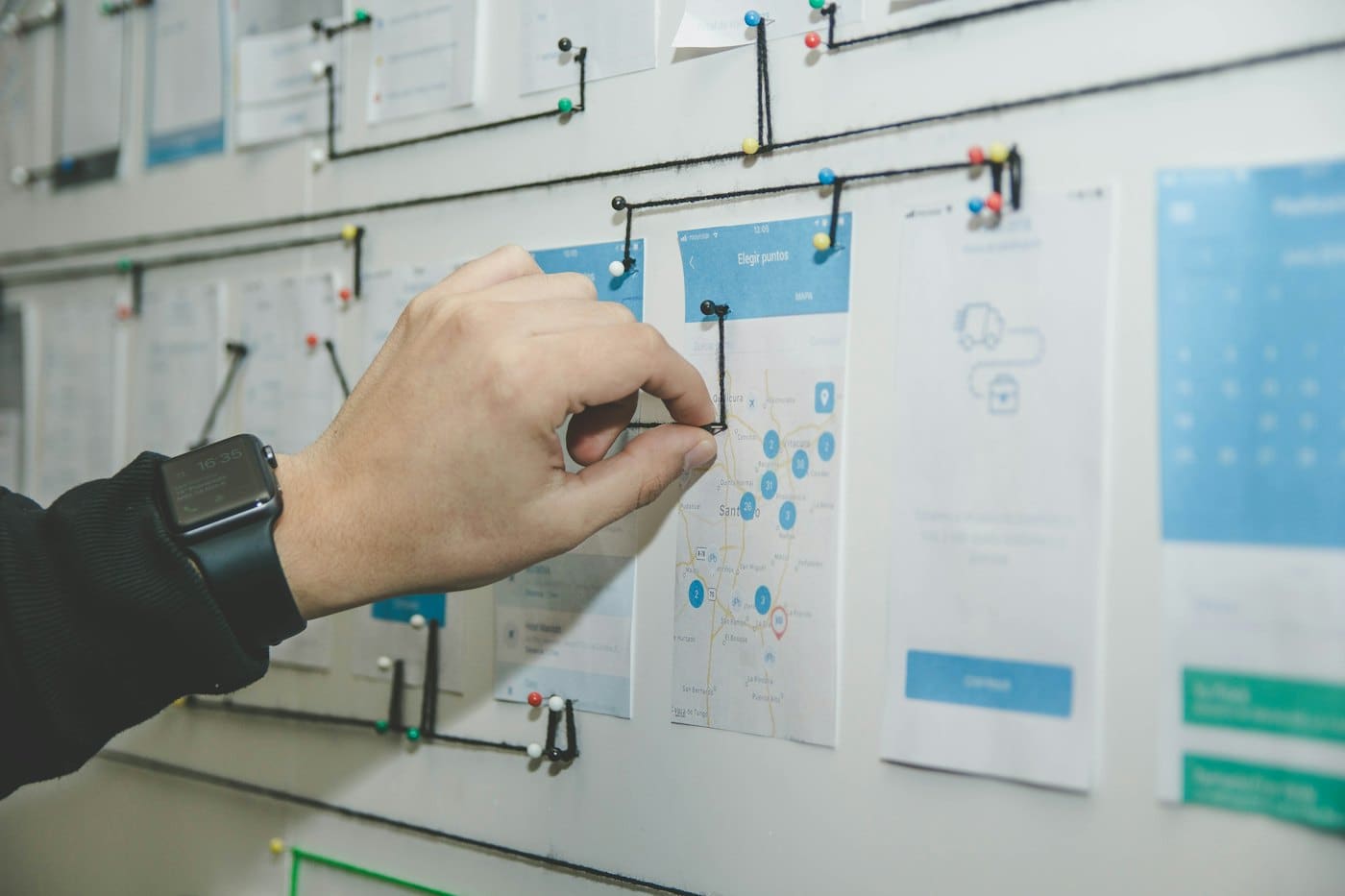 Hand arranging user-journey notes on a planning board