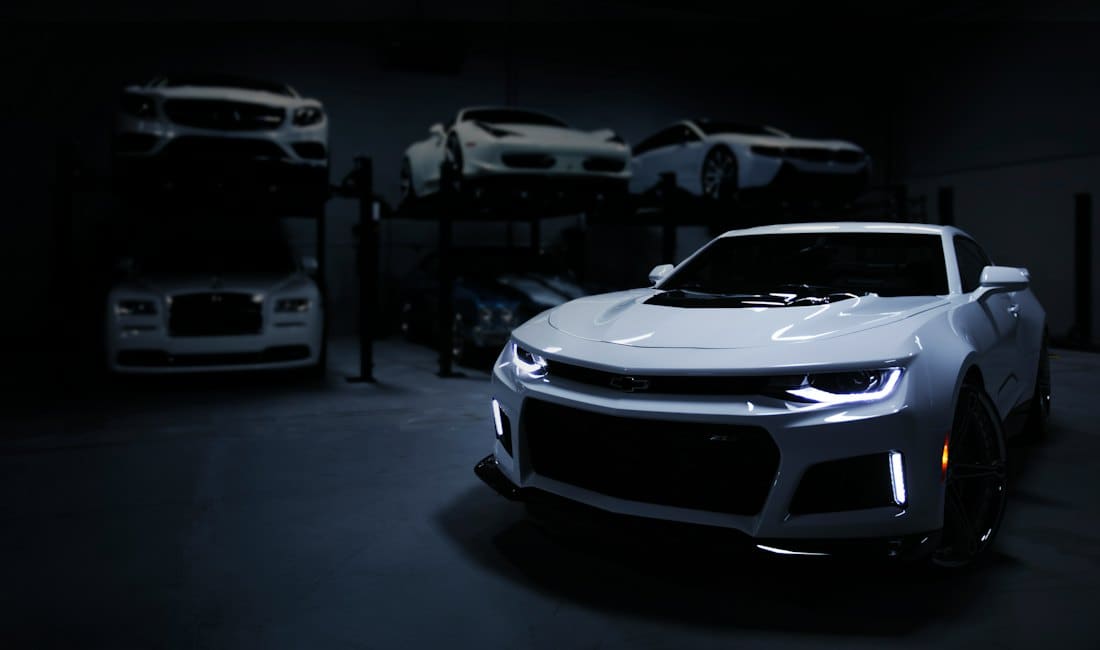 Silver muscle car under studio lights in a dark showroom