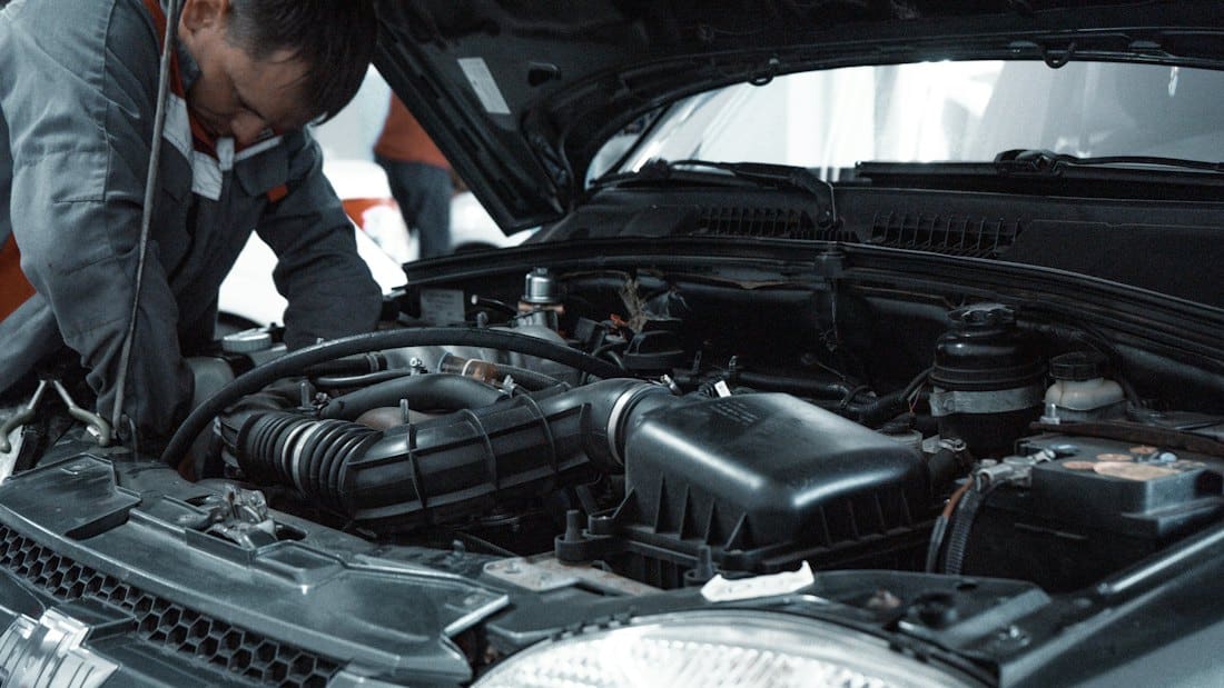 Technician inspecting an open engine bay