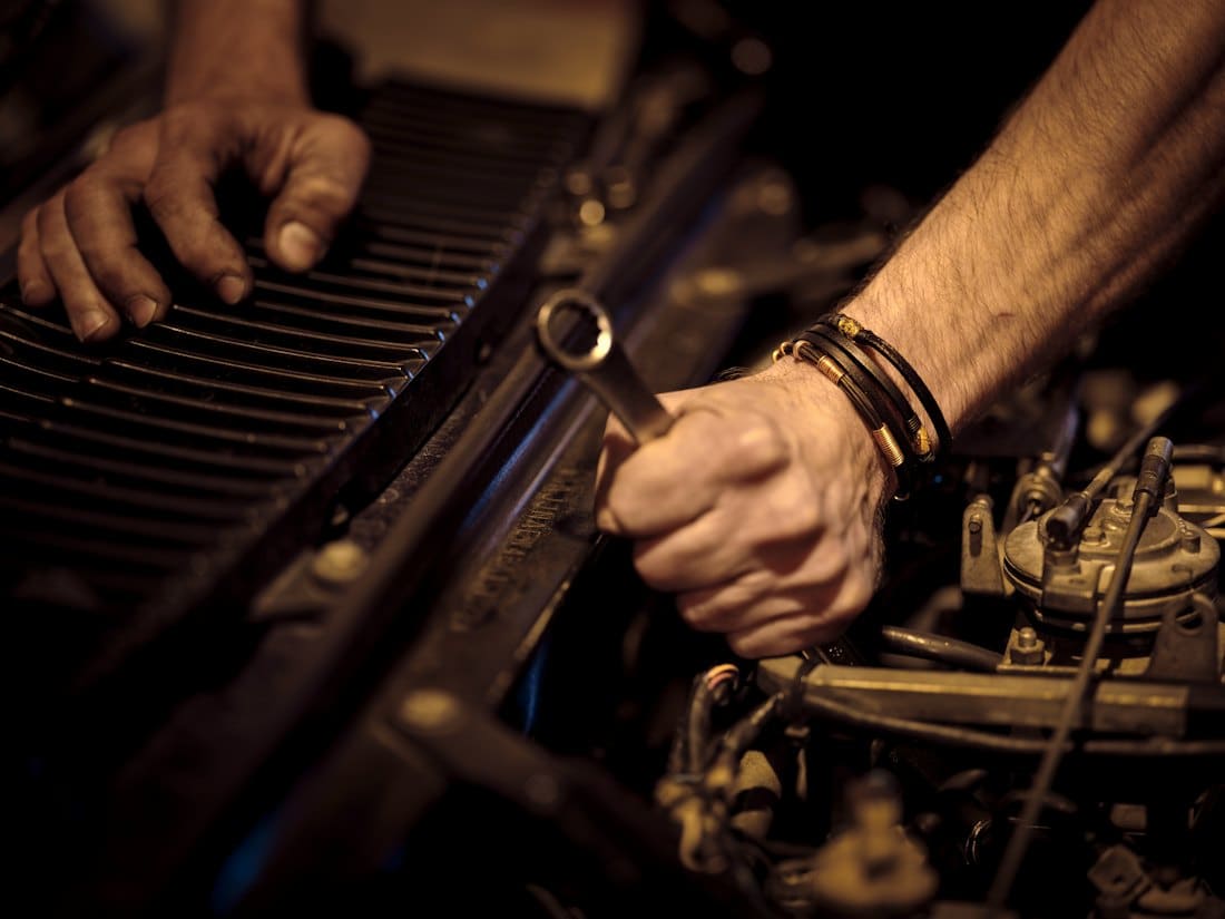 Mechanic using a wrench on an engine component