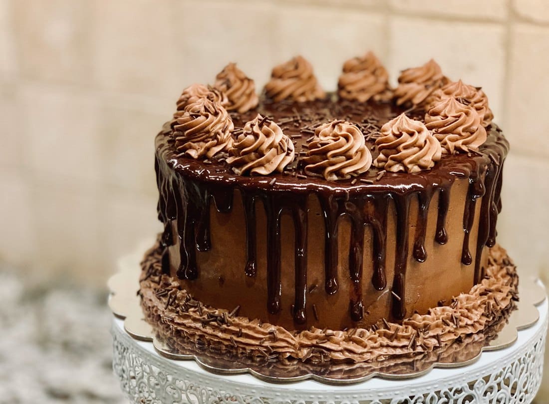 Chocolate layer cake with ganache drip and piped rosettes