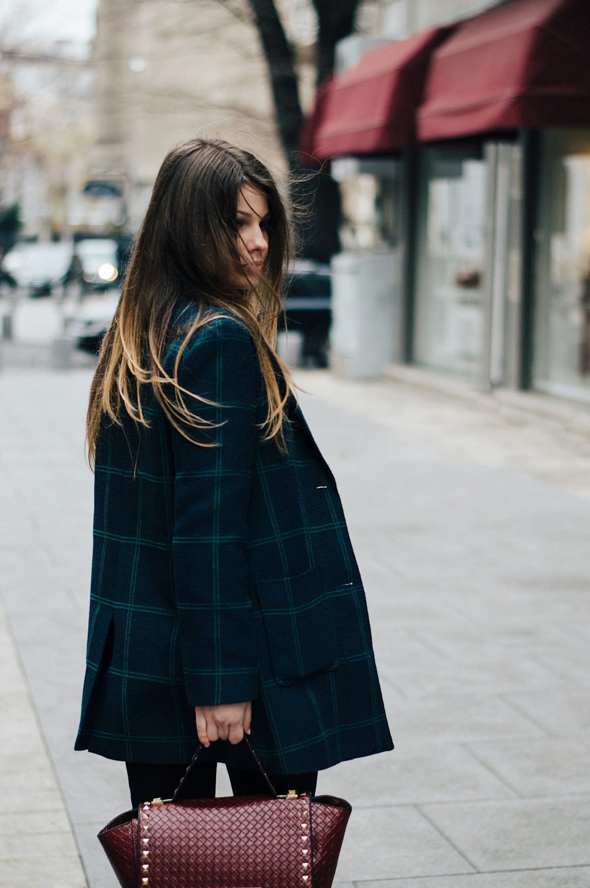 Woman on a city street in a dark tartan wool coat