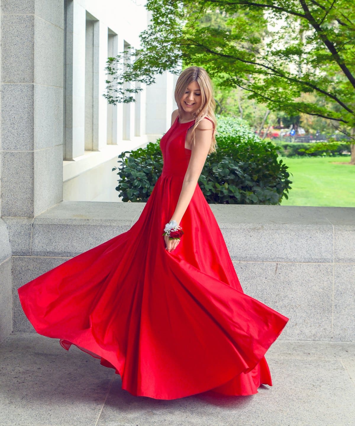 Model twirling in a floor-length scarlet silk gown