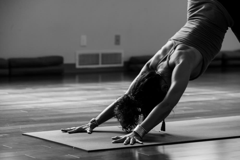 Person stretching into downward dog in the studio