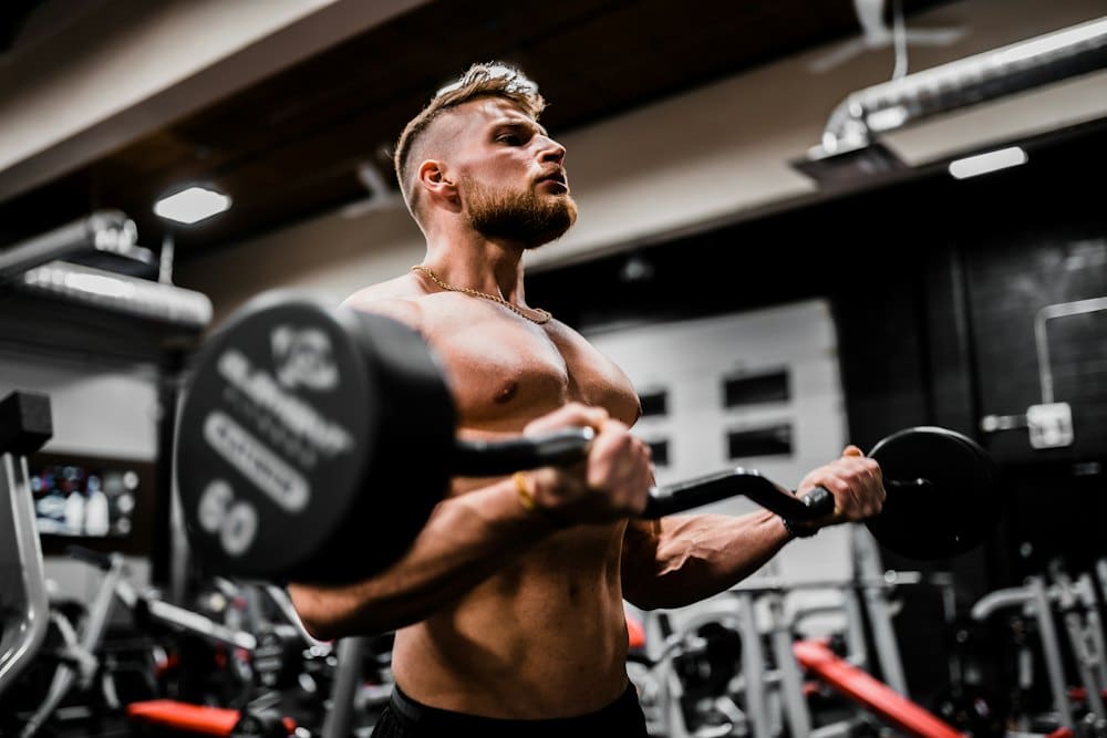 Coach Marcus performing a barbell curl in the gym