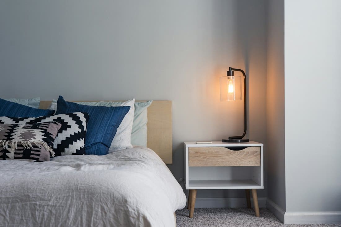 Bedroom with navy cushions and a timber bedside table