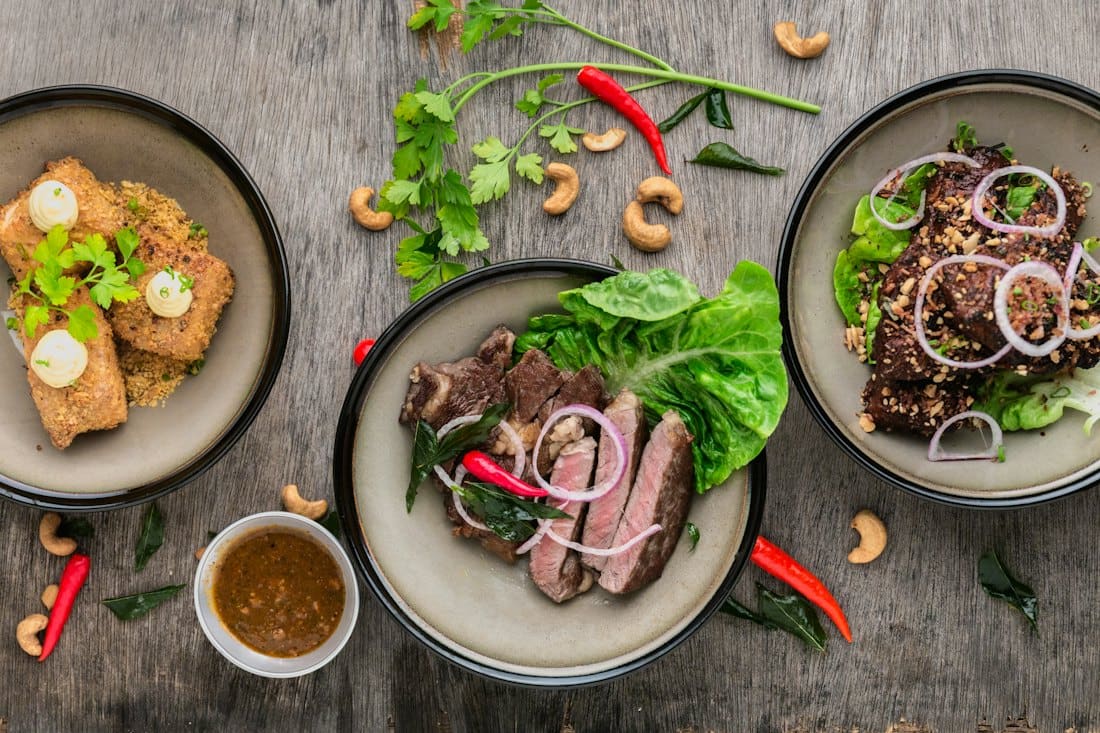 Sharing plates of seared beef, salads and spiced chicken