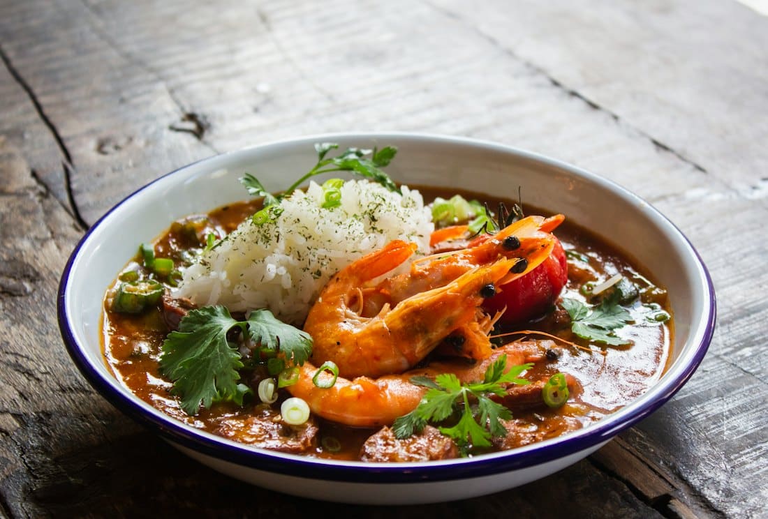 Saffron seafood curry with king prawns and rice in a white bowl