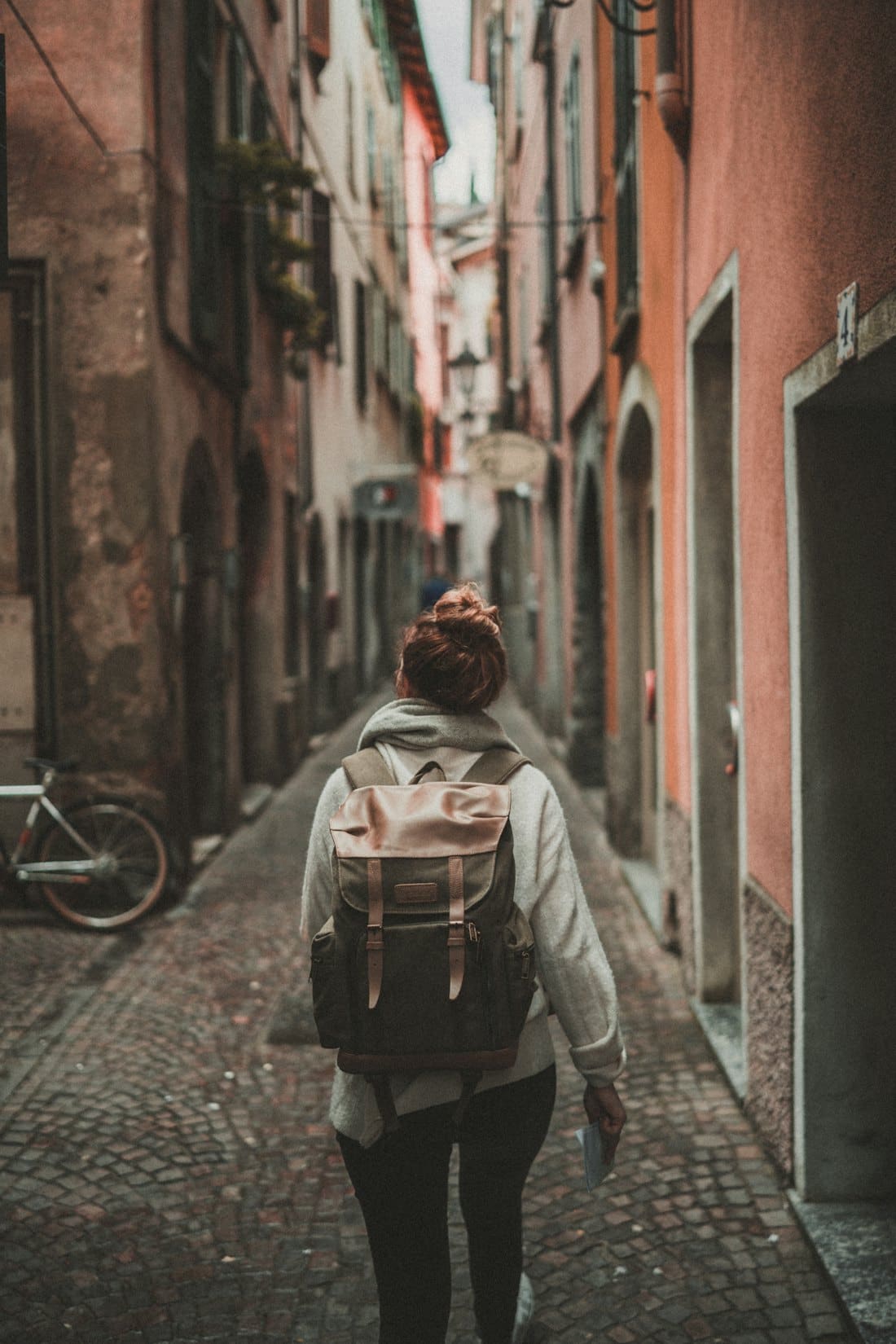 Backpacker walking through a narrow old town alley