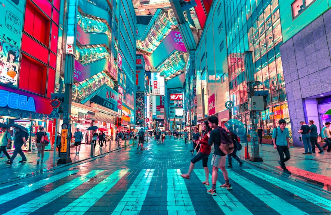 Busy neon-lit Tokyo street crossing with shoppers